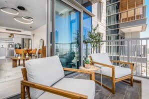 A modern living room with a sofa and armchairs, a dining area with chairs, and a kitchen in the background. - Breathtaking View Of The Old City in Jerusalem (Jerusalem)