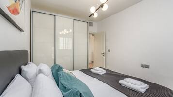 A hotel room with a bed, a large mirror, and a ceiling light fixture.