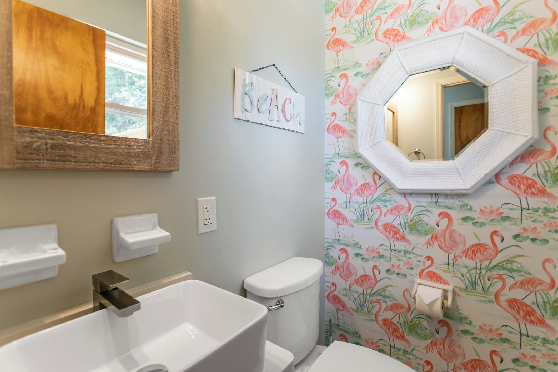 A bathroom with a large mirror, a toilet, a sink, and a shower.