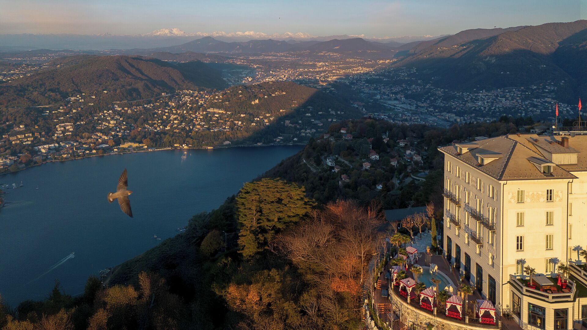 Un hotel con vistas a un lago y montañas.