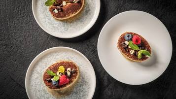Tres platos de postres sobre una superficie oscura.