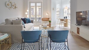 A modern living room with a sofa, two blue chairs, a coffee table, and a TV. - Getaria by FeelFree Rentals (San Sebastian)