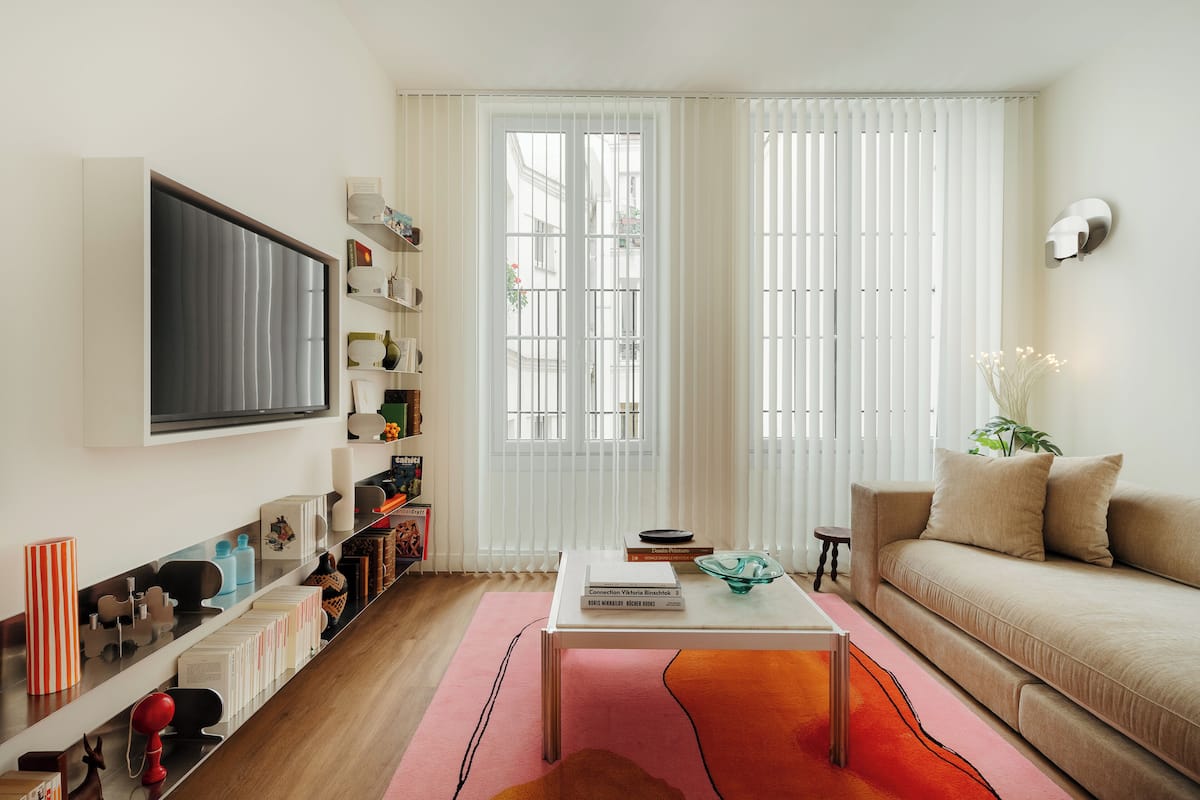 Un salon moderne avec un téléviseur à écran plat, une bibliothèque, un canapé et une table basse.