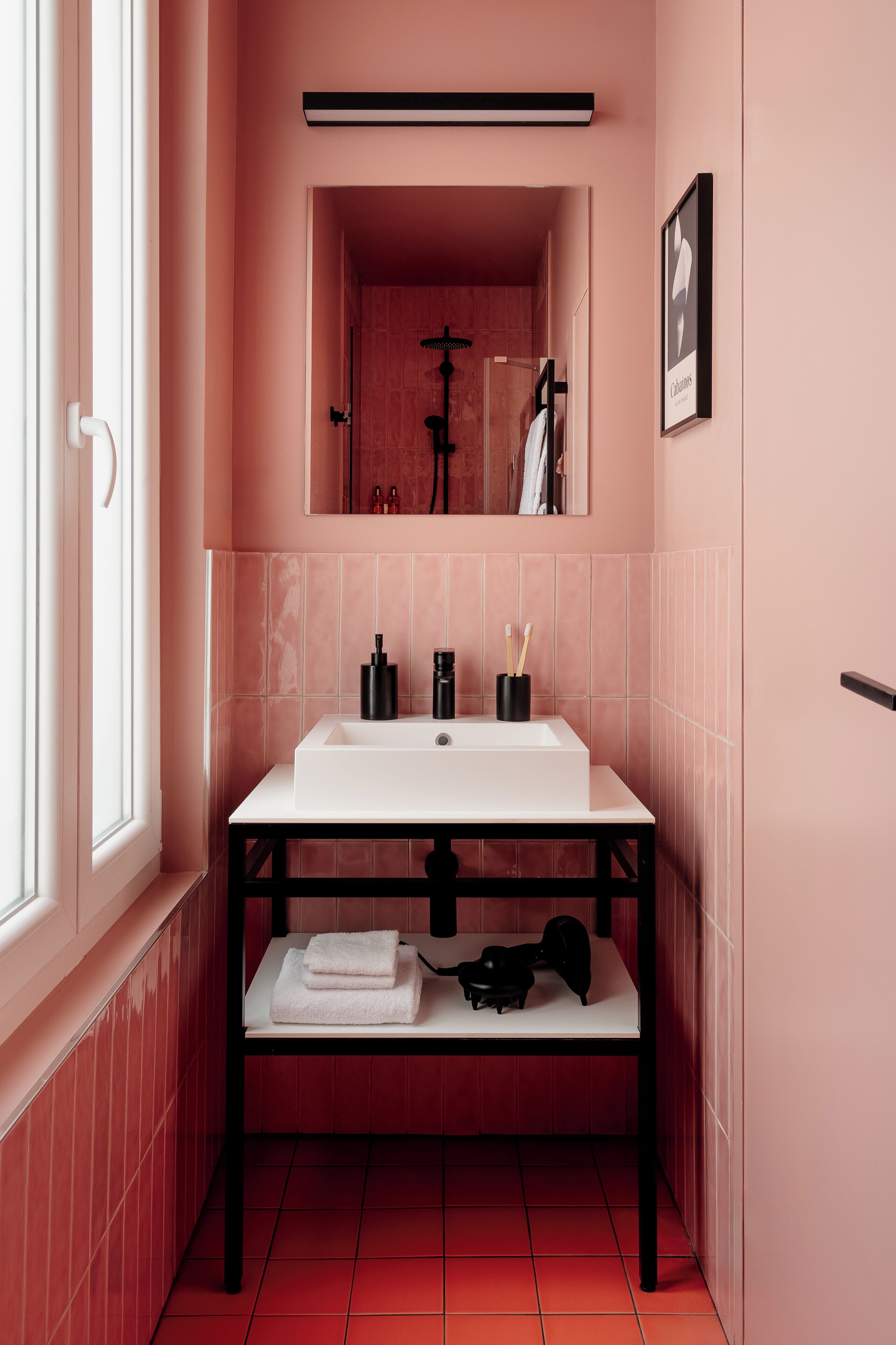 A bathroom with a white sink, black faucet, and a towel rack.