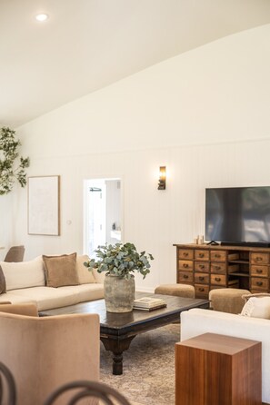 Een smart-tv, een tafeltennistafel, boeken en een kantoor