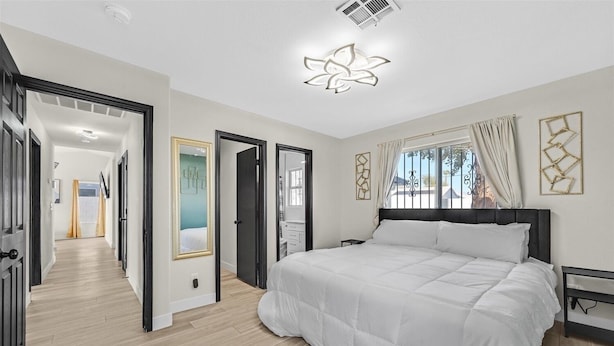 A bedroom with a large bed, a walk-in closet, and a bathroom with a mirror. - Vegas Jackpot: With Pool & Spa (North Las Vegas)