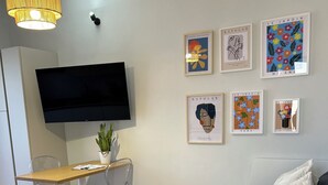 Une chambre à coucher moderne, équipée d’un lit, d’un bureau et d’une télévision.