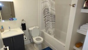 A bathroom with a toilet, sink, and shower.