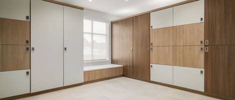 A modern room with built-in wardrobes, a large window, and a bench.