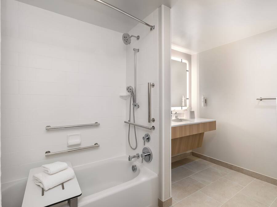 A modern bathroom with a bathtub, shower, and vanity.