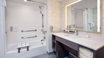 Un baño moderno con bañera, tocador con espejo y zona de ducha.