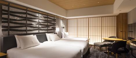 Una habitación de hotel moderna con una cama grande, un escritorio y un espacio de descanso.