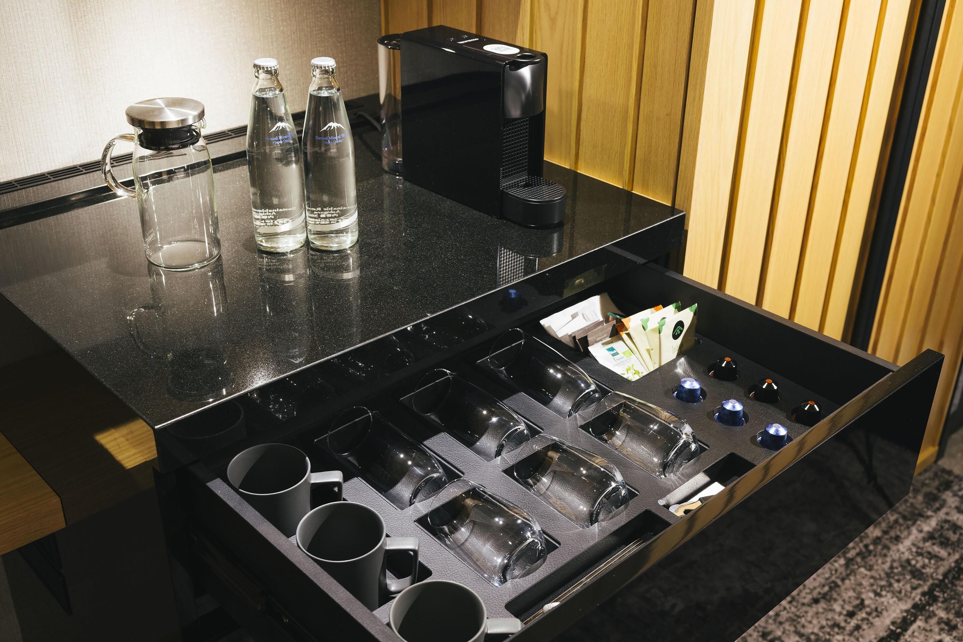 A bar area with a coffee machine, bottles, and a mug rack.