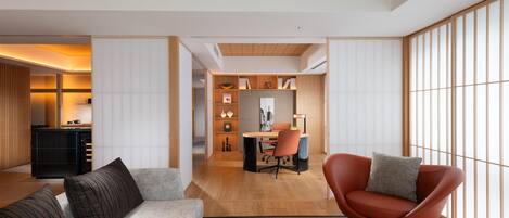 A modern living room with a sofa, armchair, and dining area.