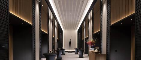 A modern hotel corridor with a central walkway, flanked by dark wooden paneling and illuminated by recessed ceiling lights.