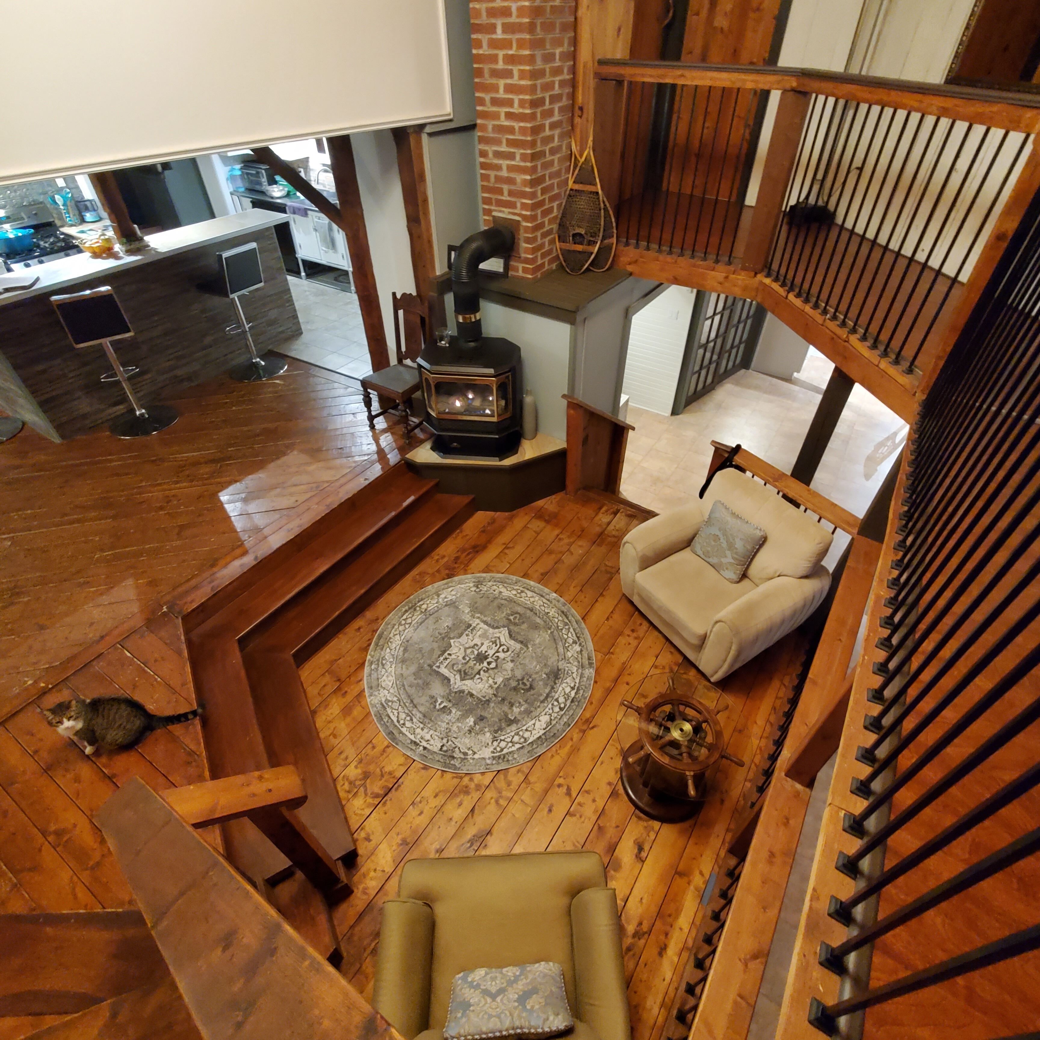A spacious living area with a wooden floor, a sofa, a coffee table, and a fireplace.