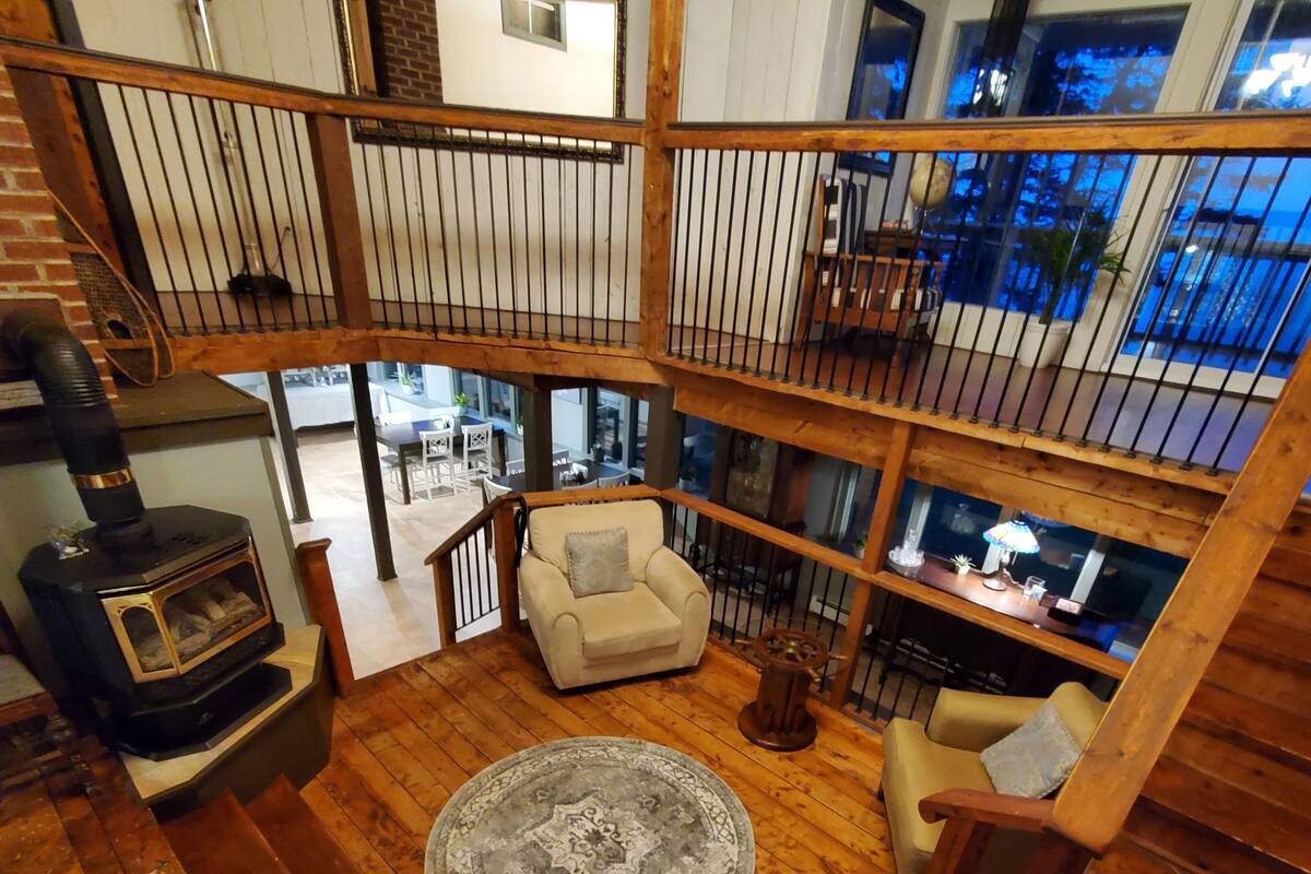 A multi-level wooden interior with a fireplace, a sofa, and a dining area.