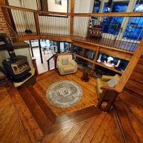 A multi-level wooden interior with a fireplace, a sofa, and a dining area.