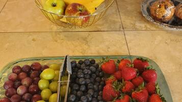 A fruit display with bananas, apples, grapes, blueberries, and strawberries.