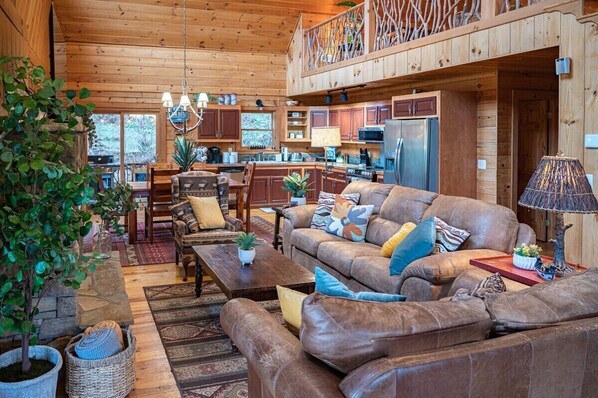 A cozy cabin interior with a living room, dining area, and kitchen.