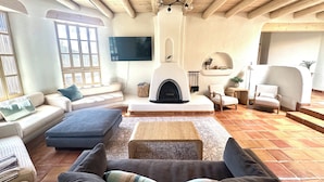 Amplia sala de estar con chimenea, sofás y televisor.