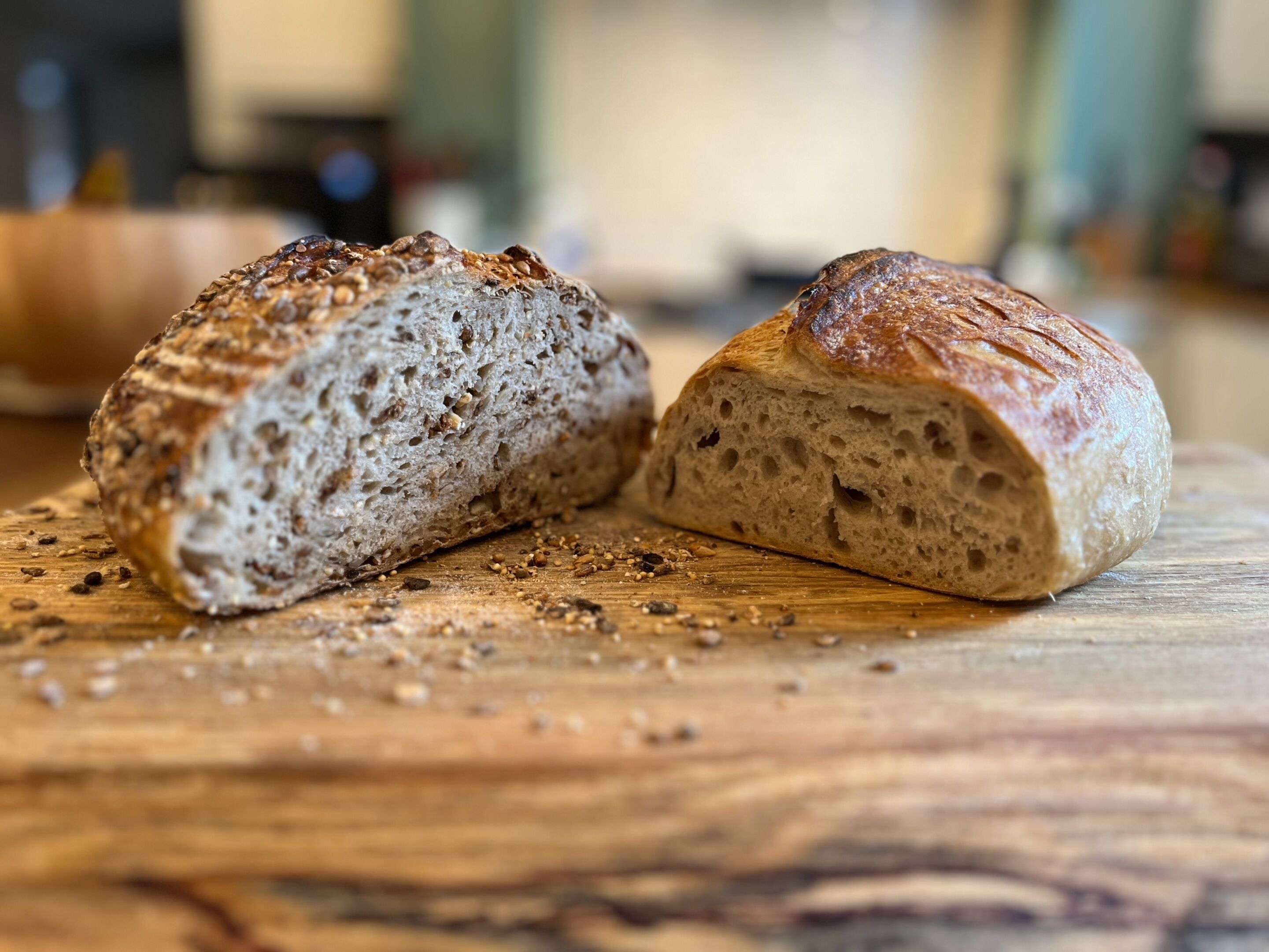 Una hogaza de pan con semillas sobre una tabla de madera.