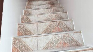 Una scala con piastrelle decorate che conduce a una porta.