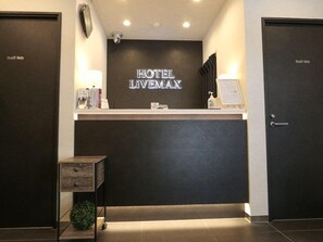 A hotel reception desk with a 'HOTEL LIVEMAX' sign, a small desk with a lamp, and two closed doors labeled 'Staff Only'. - HOTEL LiVEMAX Tokyo Kanda-Ekimae (Tokyo)