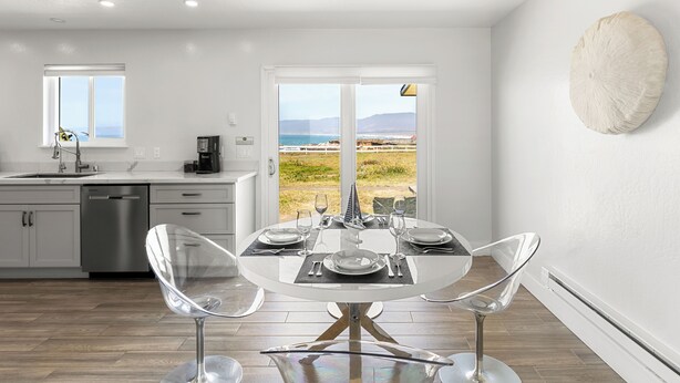 A modern kitchen with a dining area, large windows, and a view of the beach. - Point Arena Lighthouse - Head Keeper's House (Point Arena)