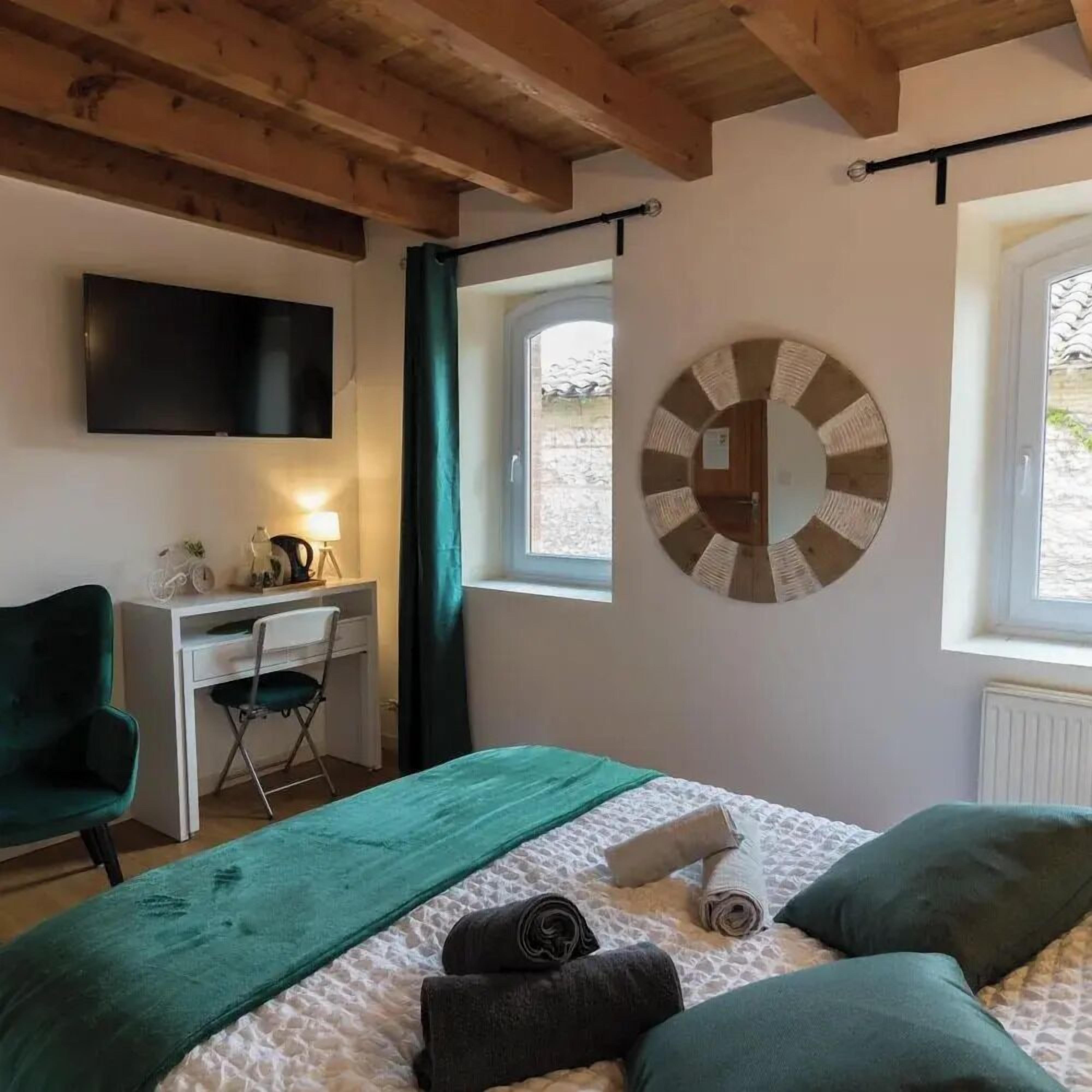 Une chambre à coucher avec un lit, un bureau, une chaise, une télévision et une fenêtre.