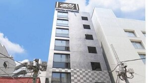 A hotel building with a checkered facade, a visible entrance, and a sign reading "HOTEL LIVESMAX". - HOTEL LiVEMAX Nihonbashi-Ningyocho (Tokyo)
