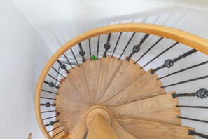 A wooden spiral staircase with a white wall background. - 2BDR Hidden Gem in the Heart of Clapham (London)