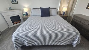 A neatly made bed with a striped bedspread and a single dark pillow. - Point Arena Lighthouse - Assistant Keeper's House 2 (Point Arena)