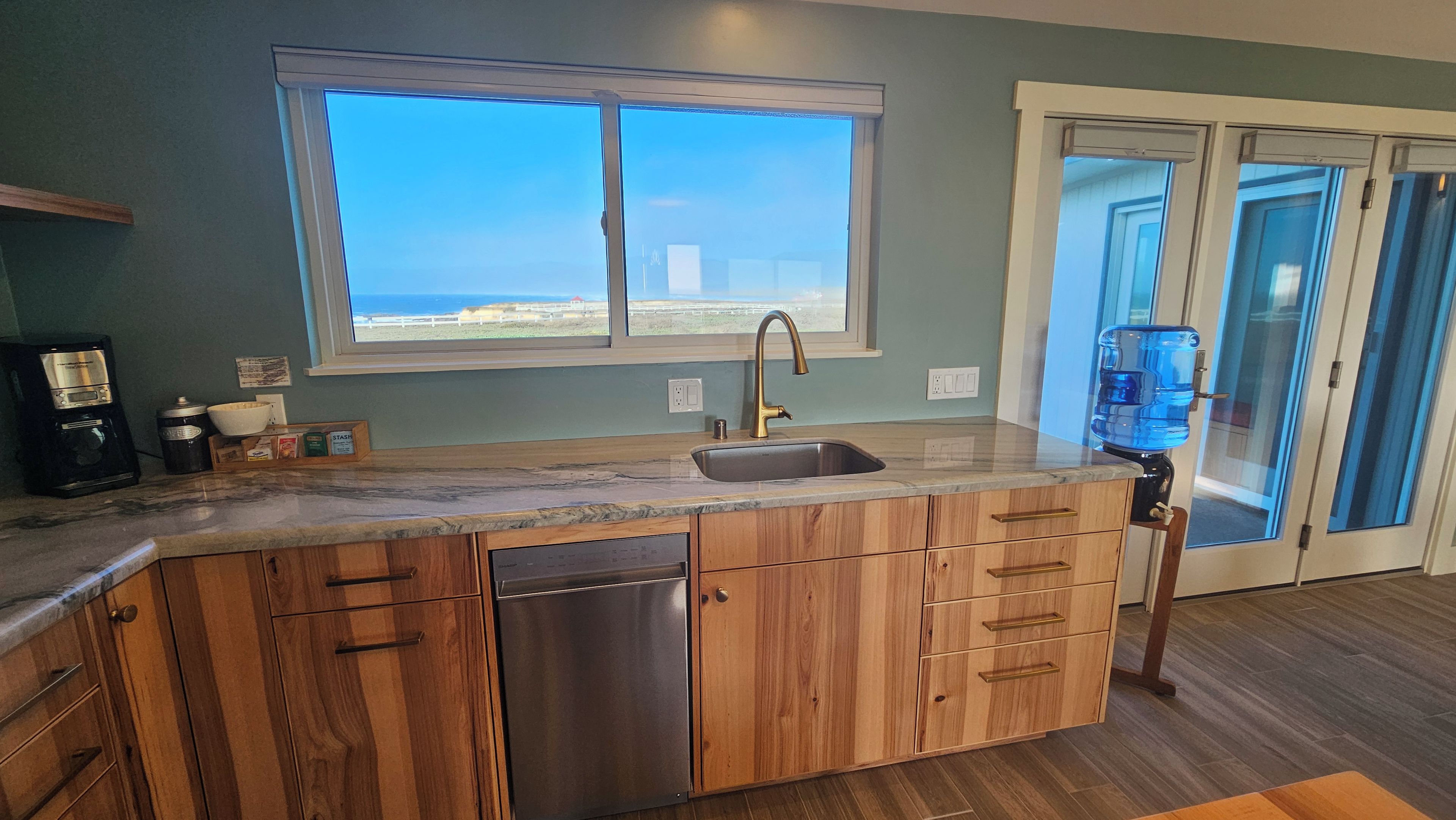 A kitchen with a built-in dishwasher, a sink, and a window overlooking a scenic view.