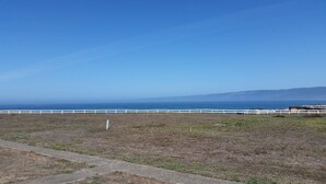 A coastal landscape with a white fence and a clear view of the ocean. - Point Arena Lighthouse - Assistant Keeper's House 3 (Point Arena)