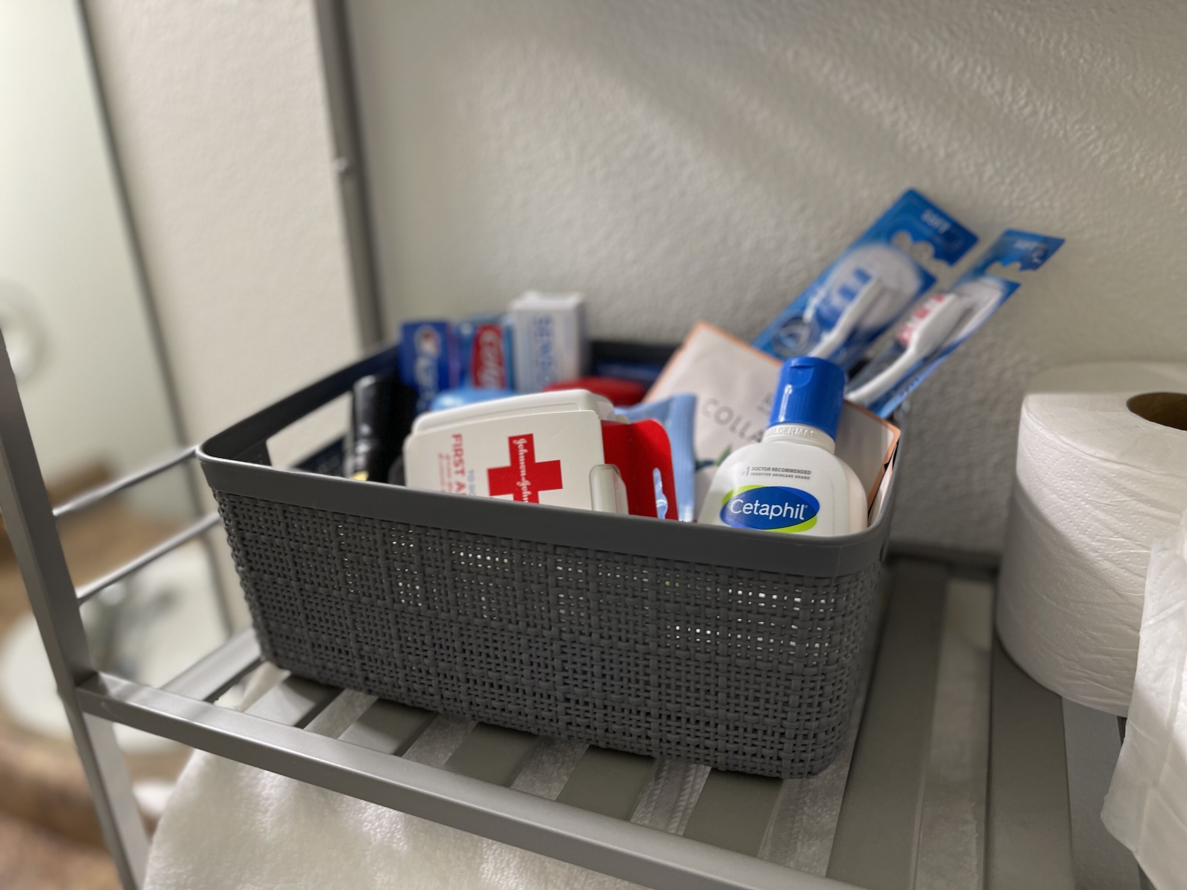 A basket containing medical supplies and toiletries on a shelf.