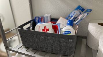 A basket containing medical supplies and toiletries on a shelf.