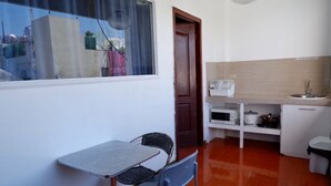 Una cucina compatta con zona pranzo, comprensiva di tavolo, sedie e forno a microonde.