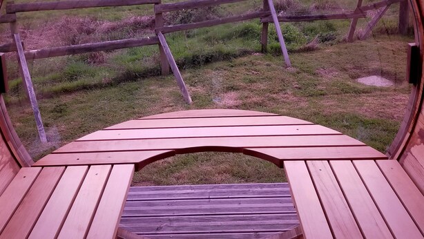 A circular wooden structure with a view of a grassy field and a wooden fence. - Lodge Cèdre Private Spa and Sauna, in a Green Environment, View of the Morvan (BRAZEY EN MORVAN)