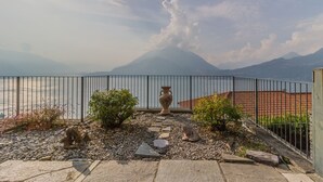 Ein Balkon mit Blick auf einen Berg und ein Gewässer.