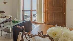 Ein Zimmer mit einem Glastisch, einem Buch und einem dekorativen Zweig.