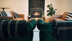 Una sala de estar con chimenea, dos sofás y una mesa de centro.