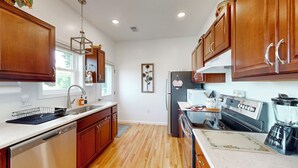 A kitchen with wooden cabinets, a stainless steel refrigerator, a microwave, and a stove. - Lake & Vineyard View (Pulteney)