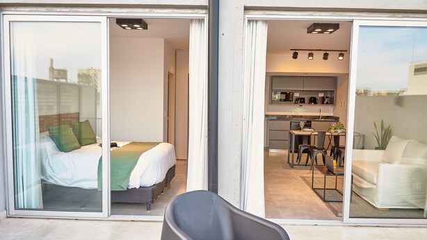 A modern apartment with a bed, a sofa, and a dining area. - Babel Campus (Buenos Aires)