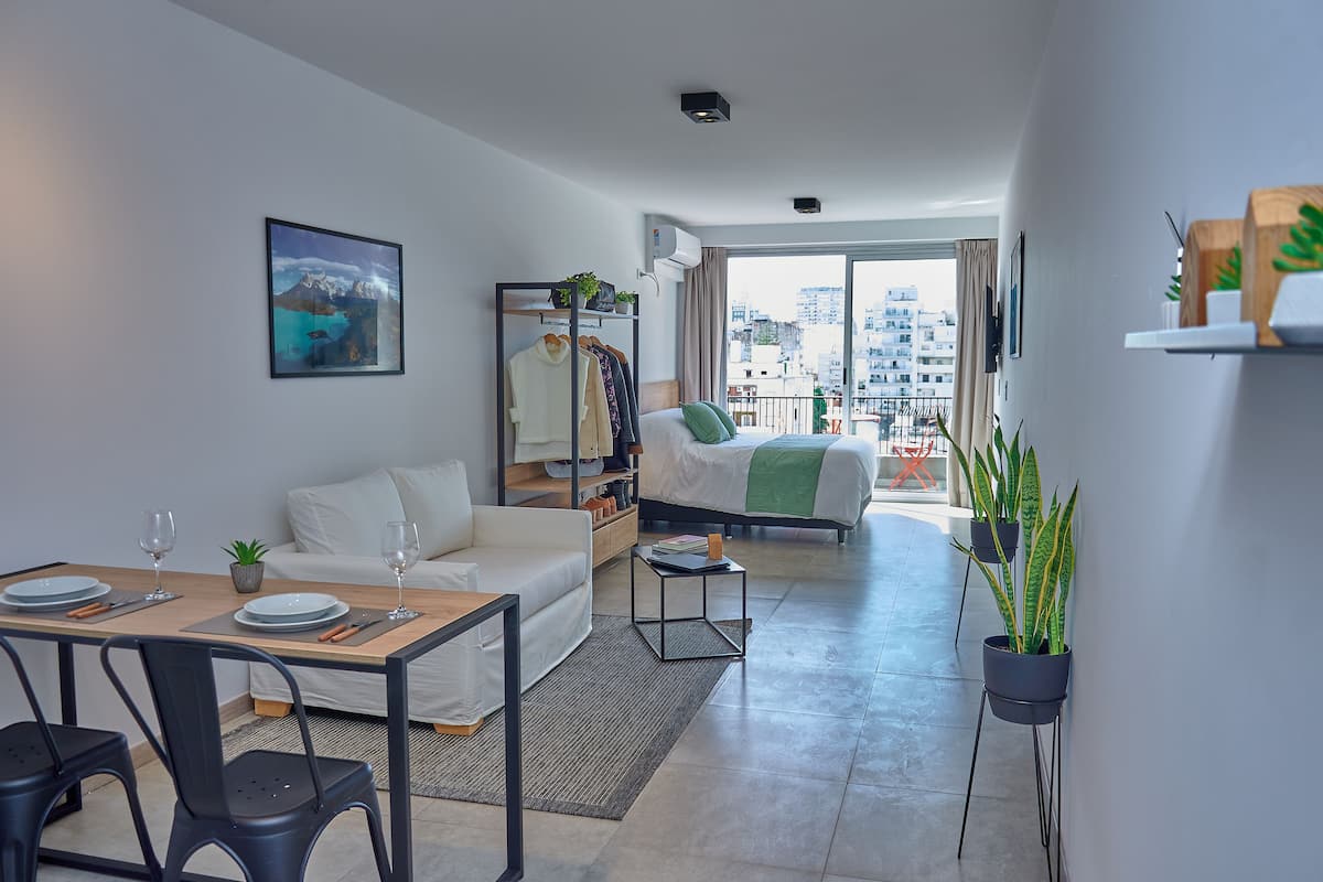 A modern apartment with a dining area, a living room, and a bedroom.