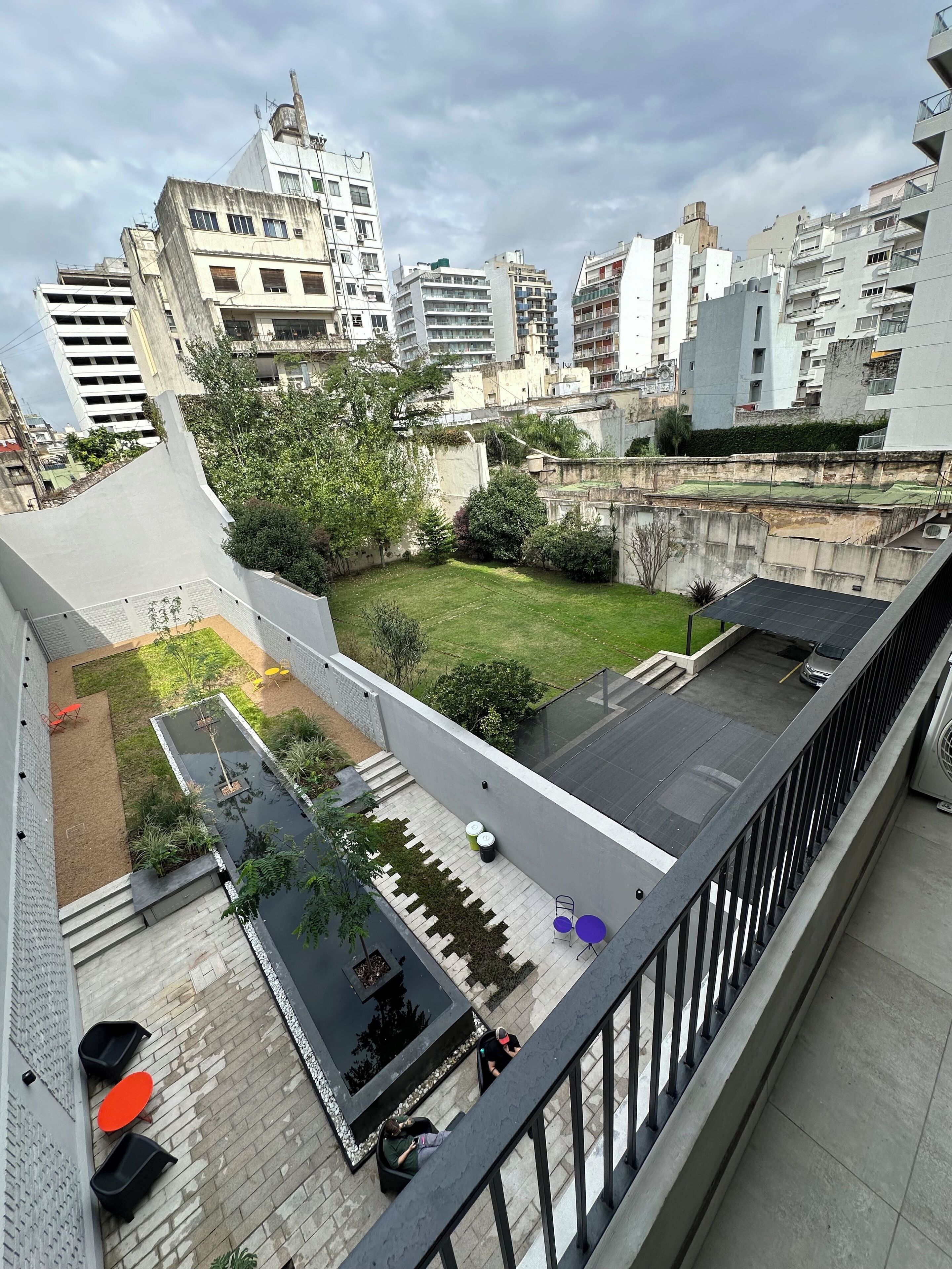 Terraza en la azotea con jardín pequeño, zona de estar y vistas a la ciudad.