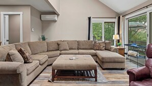 A spacious living room with a large sectional sofa, a matching ottoman, and a leather armchair. - Alpine Escape by Avantstay On Camelback Mountain, Near Waterpark/attractions (Tannersville)