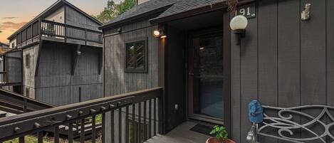 Une maison en bois avec un balcon et un banc.