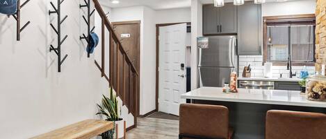 A modern kitchen with a central island, stainless steel appliances, and pendant lighting.