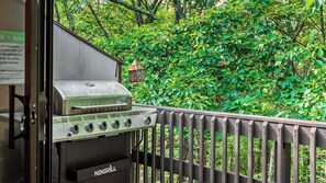 A NEXGRILL barbecue grill on a balcony with a wooden railing, surrounded by lush greenery. - Prime Location on Camelback Mtn, Renovated w/ Movie & Game Room The Bear's Den (Tannersville)